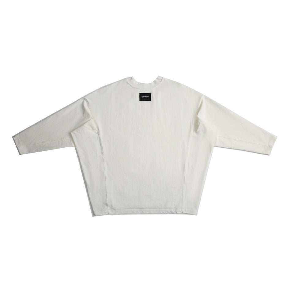Flat-lay front view of an oversized off-white crew-neck top with wide sleeves and a small sewn-in neck label.