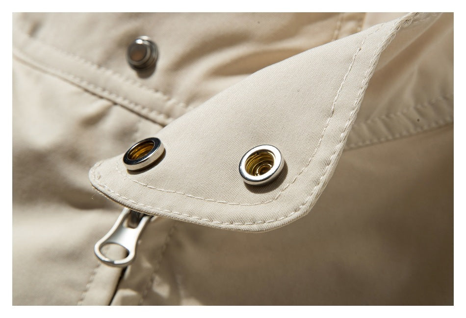 Close-up of metal eyelets on a beige garment tab beside a zipper pull.