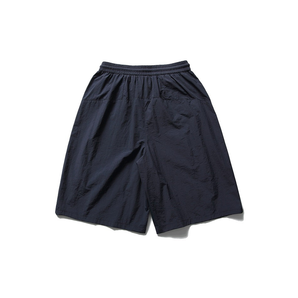 Back view of loose navy shorts with an elastic waistband and wide legs.