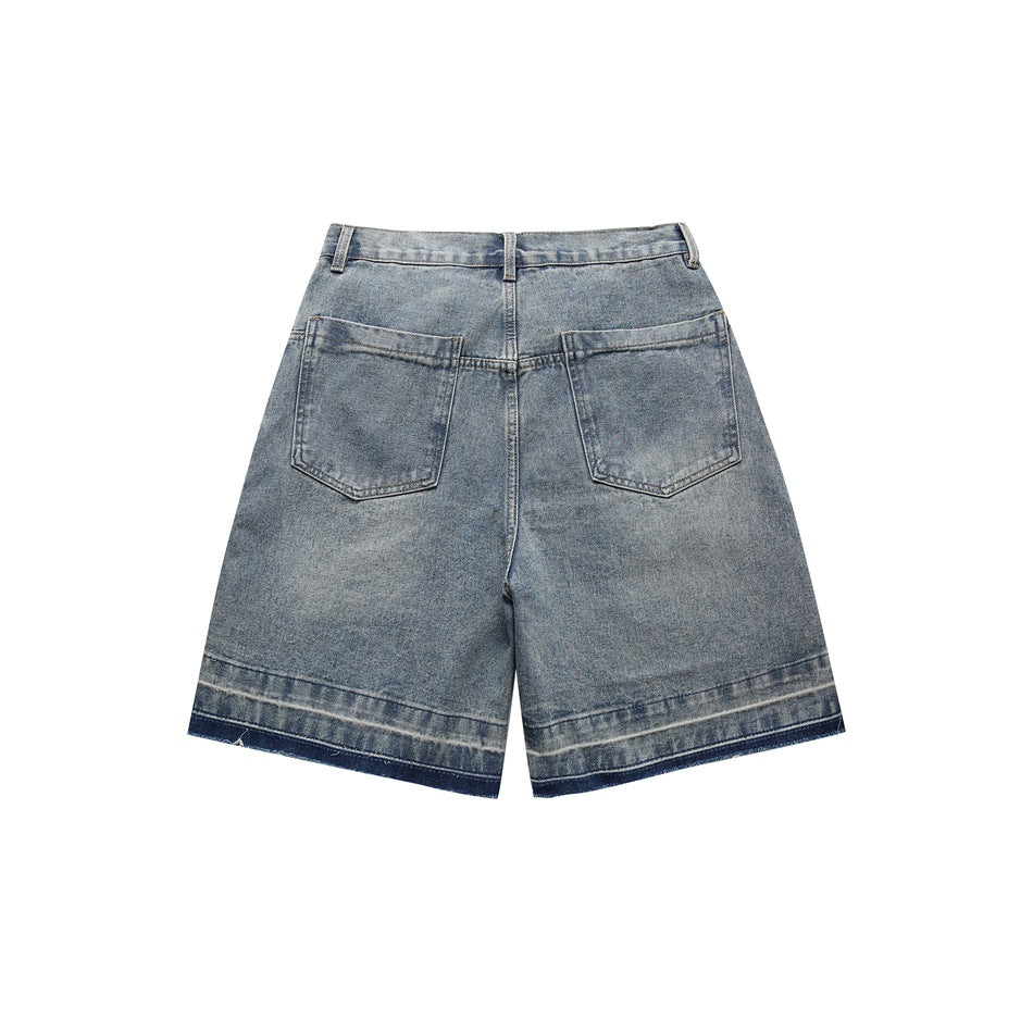 Back view of blue faded denim shorts with two patch pockets and a raw frayed darker contrast hem