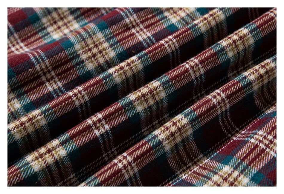 Close-up showing the texture and folds of burgundy, teal, cream, and brown plaid fabric.