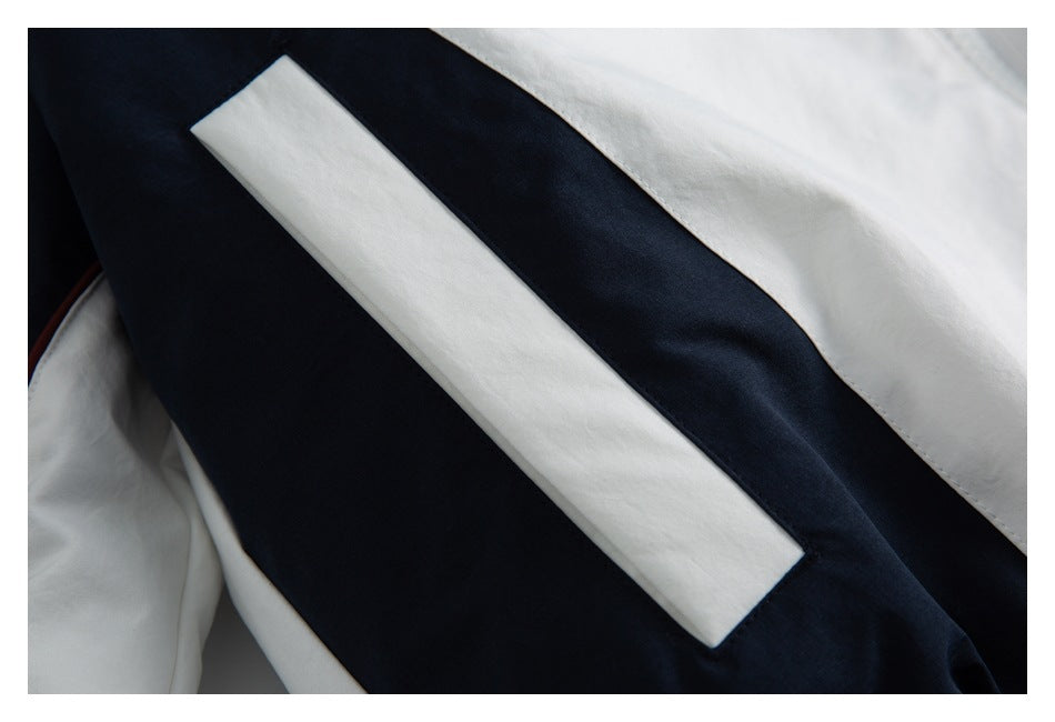 Close-up of a white rectangular panel against navy fabric on a white and navy jacket.