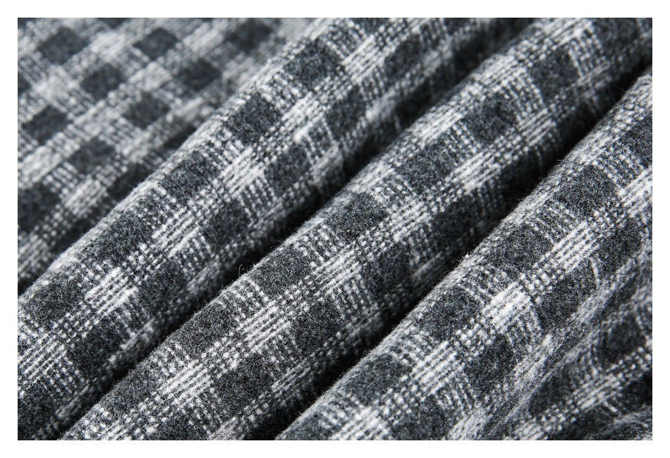Macro view of the jacket's charcoal, gray, and white plaid fabric texture.
