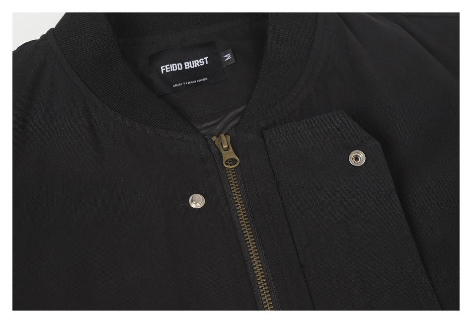 Close-up of the black jacket's collar, neck label, zipper, and snap-fastened front flap.