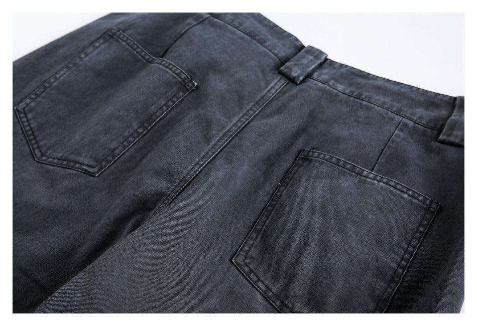 Rear view of dark charcoal jeans showing two patch pockets, the waistband and belt loops.