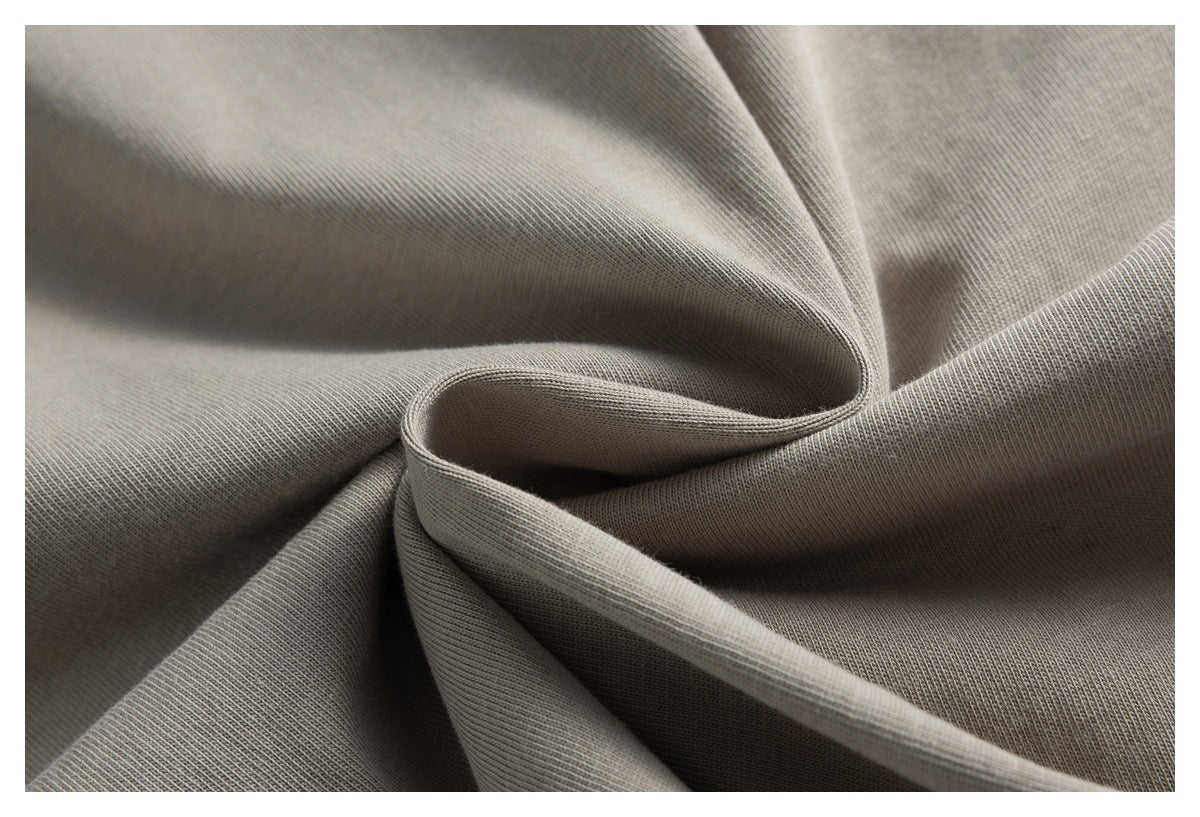 Close-up of gray-taupe fabric gathered into soft folds, showing its fine knit texture.