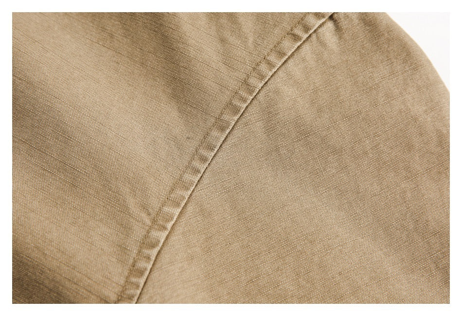 Close-up of a curved stitched seam on tan fabric.