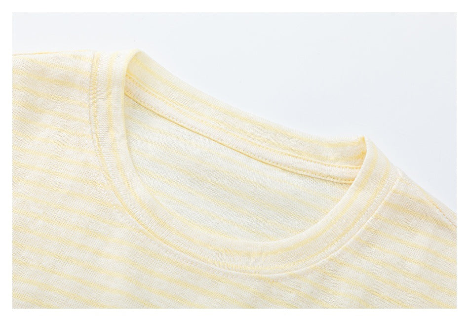 Close-up of the crew neckline and shoulder of a cream shirt with pale yellow stripes.