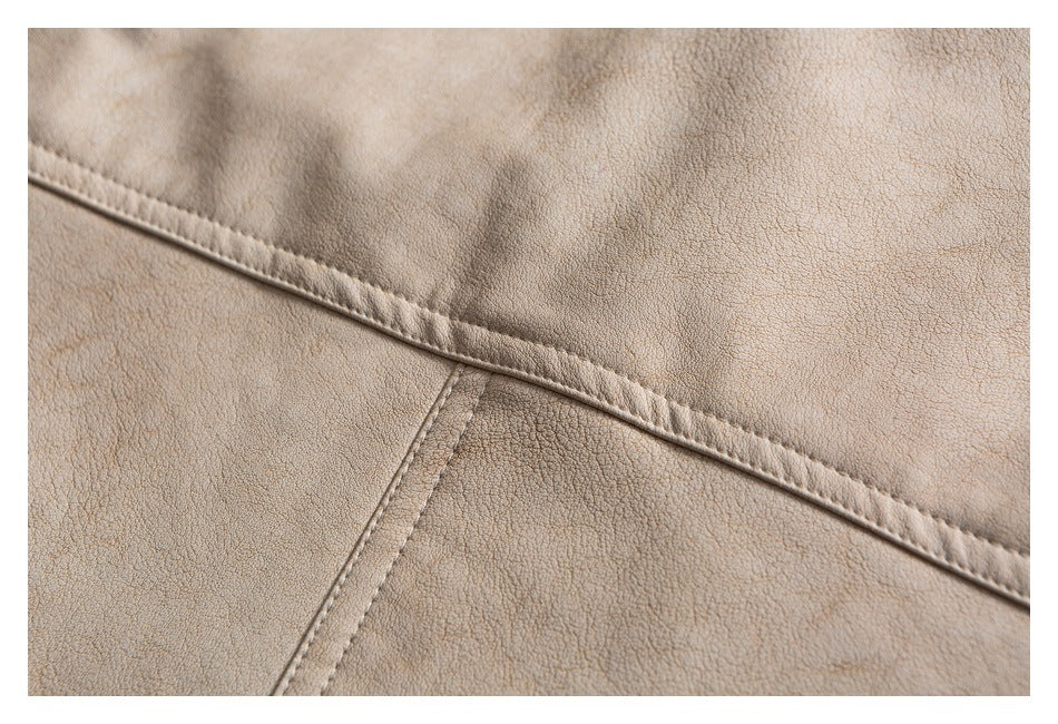 Close-up of beige garment fabric with pebbled texture and intersecting stitched seams.