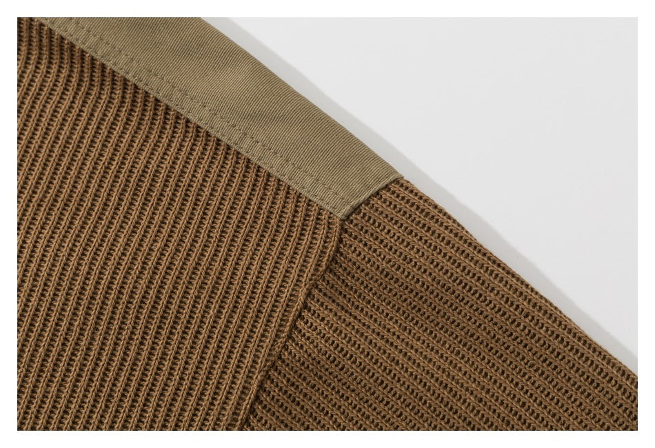 Close-up of brown ribbed knit panels joined beneath a tan fabric edge.