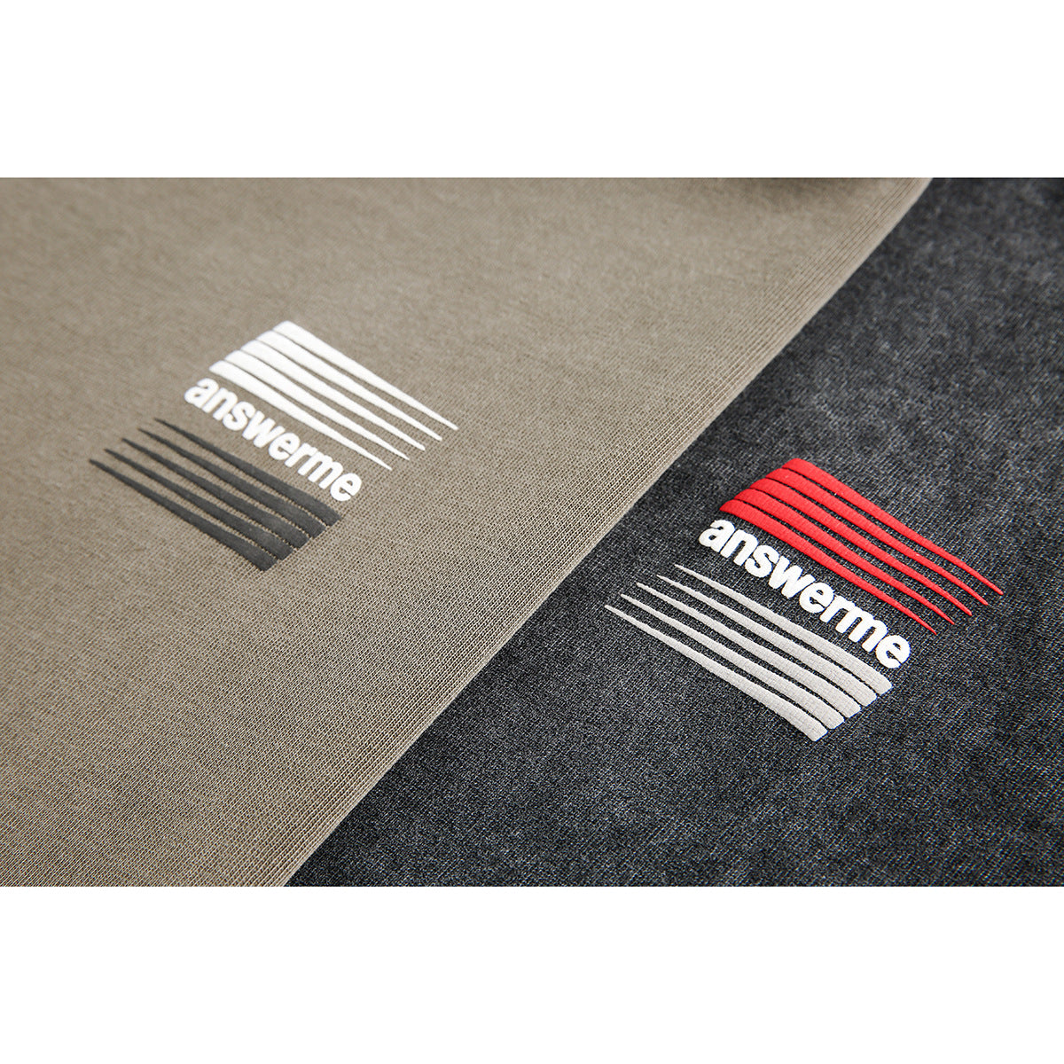 Close-up of two T-shirt prints: stripe graphics and lowercase lettering on taupe and charcoal fabric.