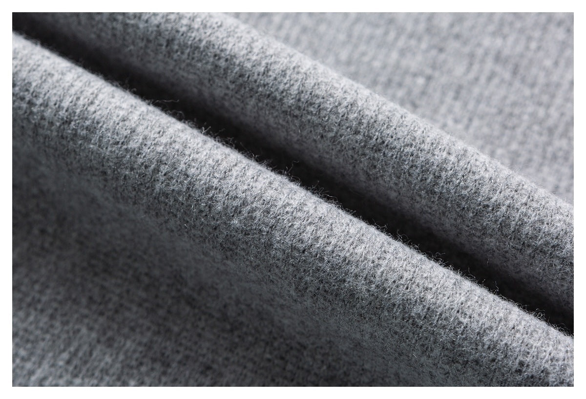 Macro view of the garment's mottled light gray textured fabric and folded edge.