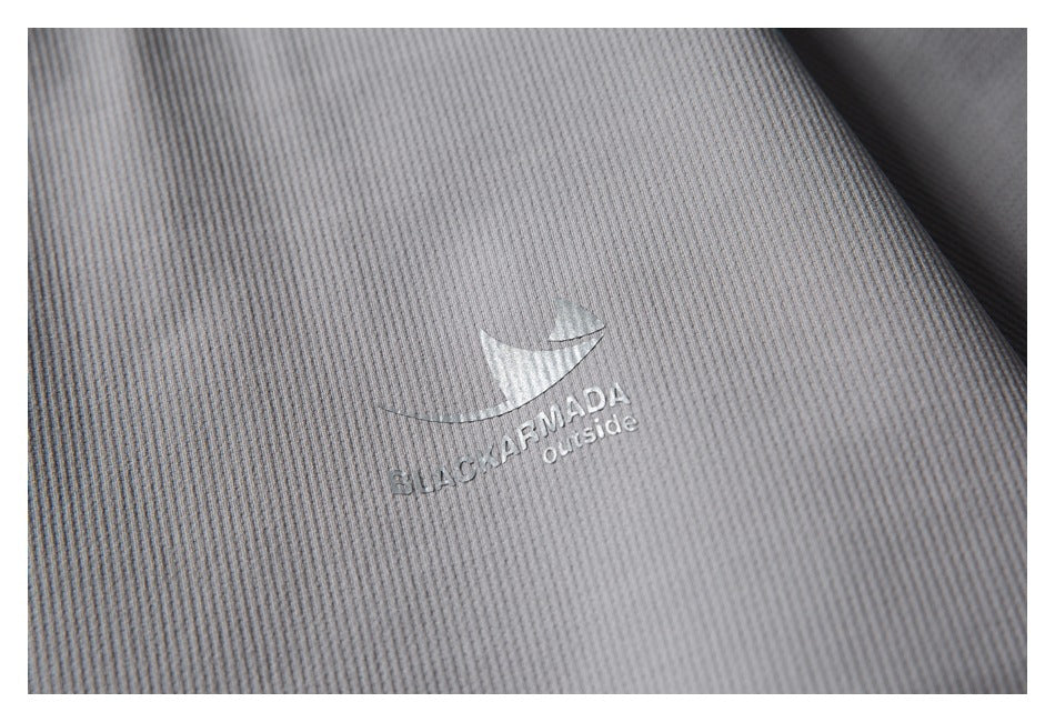 Close-up of gray ribbed garment fabric with a silver BLACKARMADA outside logo.