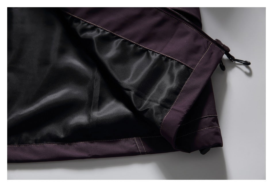 Close-up of black lining, plum panels, stitched trim, and a zipper with pull cord.