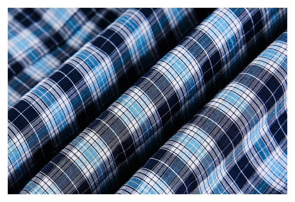 Close-up of navy, light blue, and white plaid fabric arranged in soft folds.