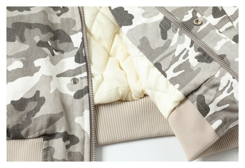 Open gray camouflage jacket showing cream quilted lining, a front zipper, snaps, and beige ribbed trim.