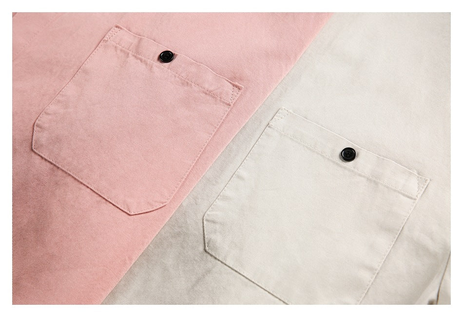 Close-up of pink and cream shirt chest pockets, each with a black button.