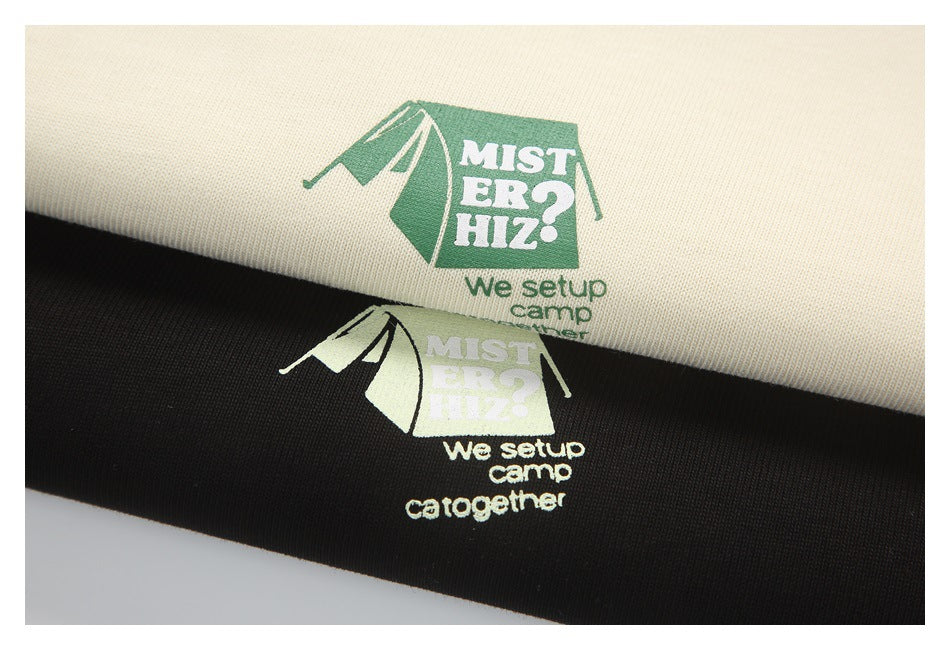Close-up of cream and black fabric swatches printed with tent graphics and English camping text.