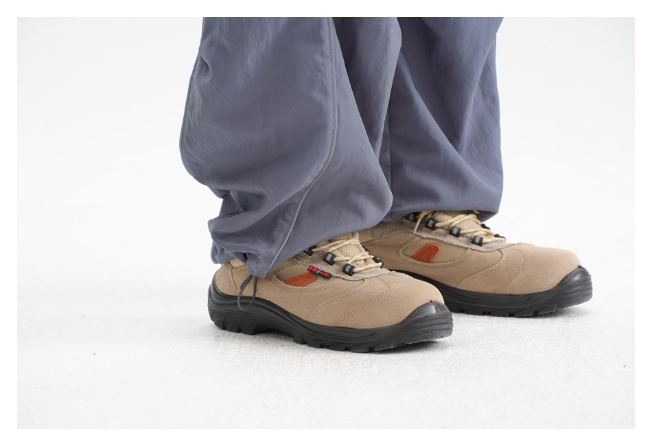 Close-up of slate-blue trouser hems over tan hiking shoes with dark soles.