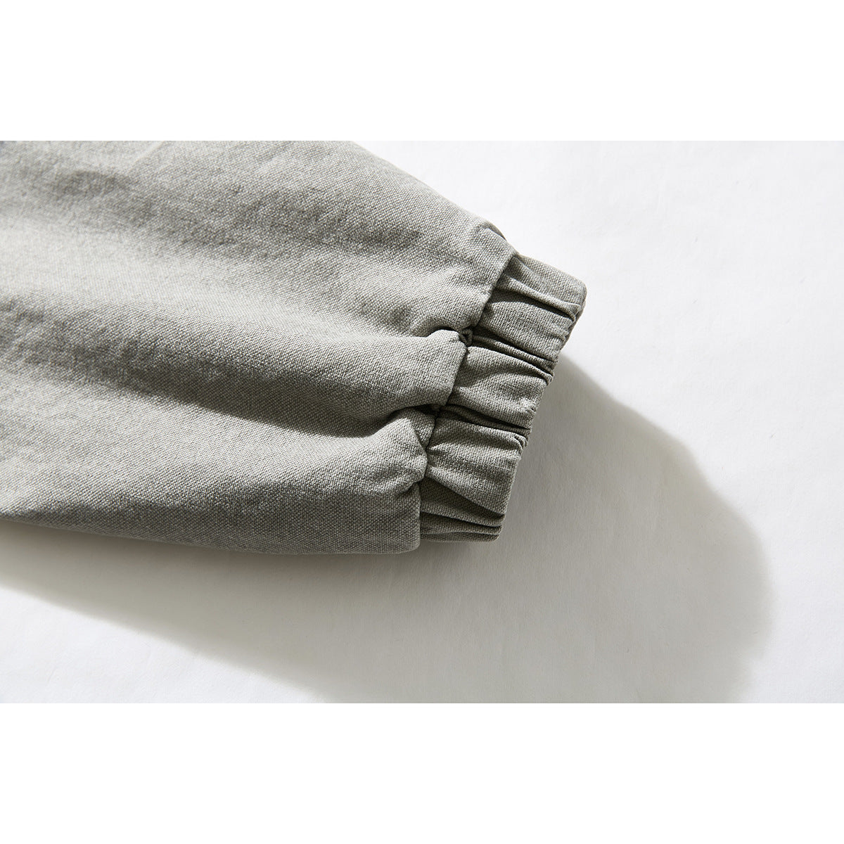 Close-up of the gray washed jacket sleeve ending in a gathered elastic cuff.