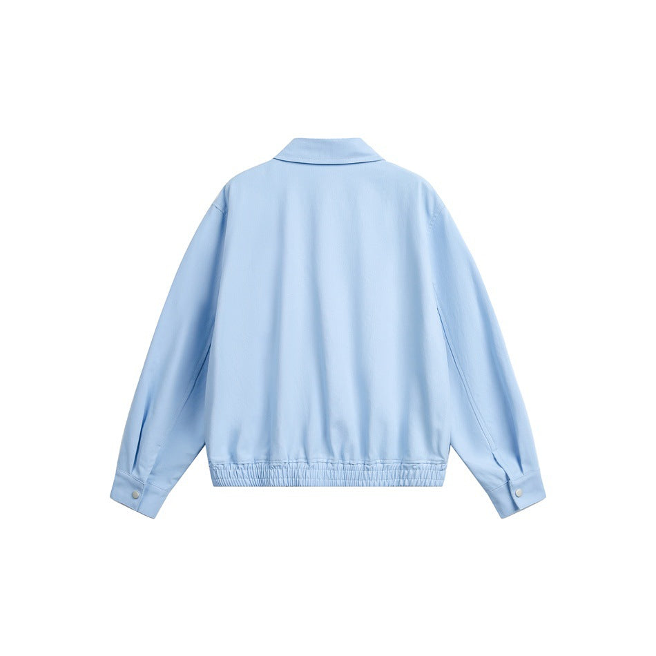 Back view of a light blue jacket laid flat, with a collar, snap cuffs, and gathered hem.