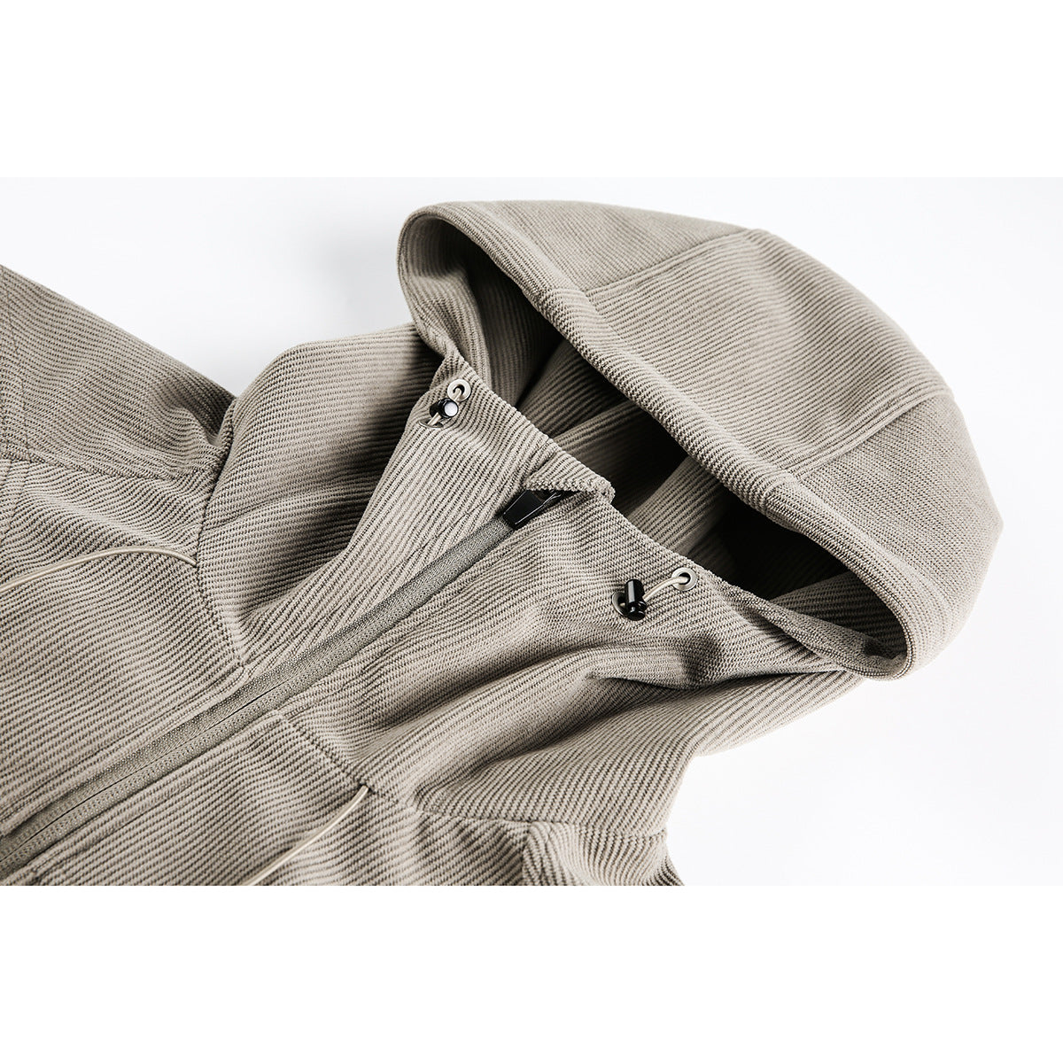 Close-up of a taupe textured jacket hood, collar, front zipper, and adjustable hood toggles.