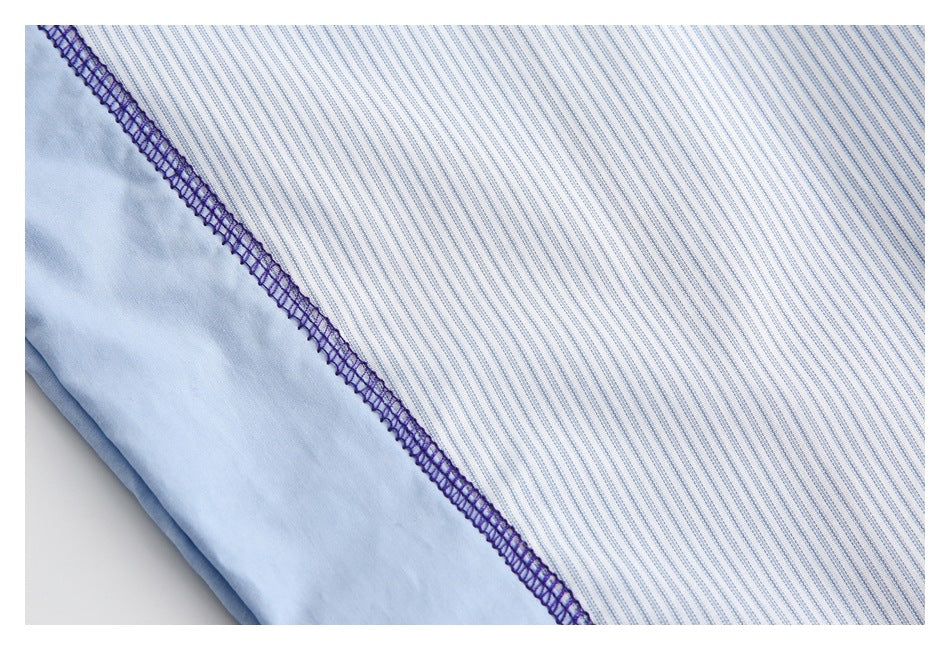 Close-up of purple overlock stitching joining blue-and-white striped fabric to a pale blue panel.