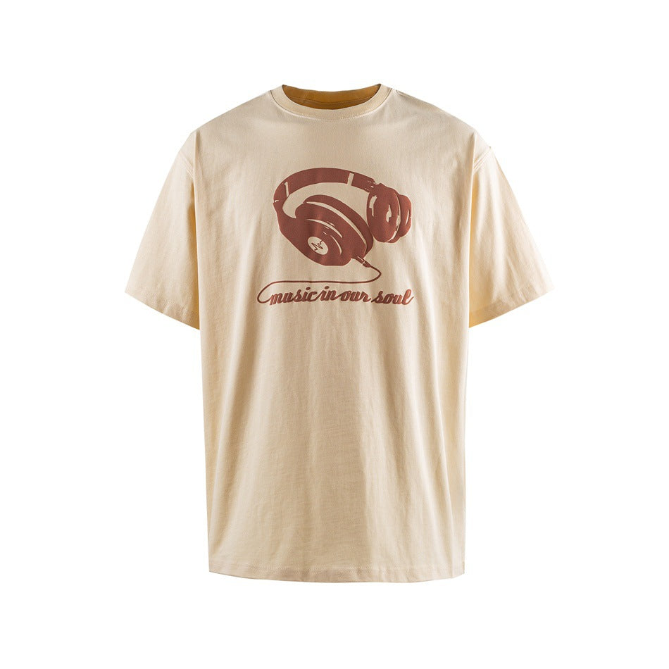 Light apricot short-sleeve T-shirt with brown-red headphone graphic and 'music in our soul' script, front view