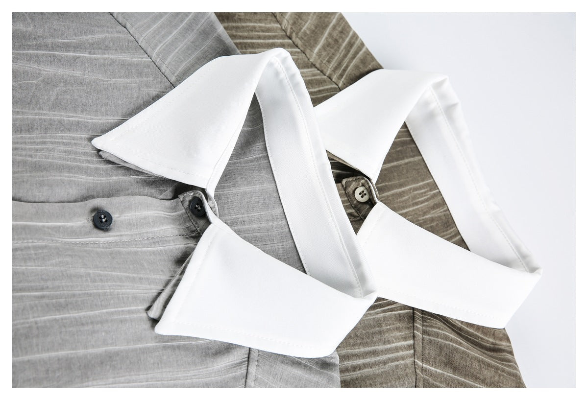 Close-up of two gray striped shirts showing their contrasting white collars and dark buttons.