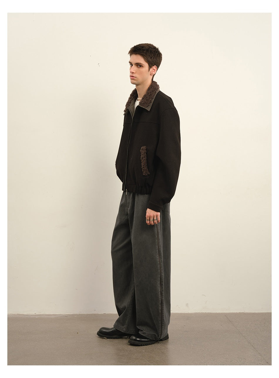 Side view of a model wearing a black zip jacket with a brown textured collar and pocket trim.