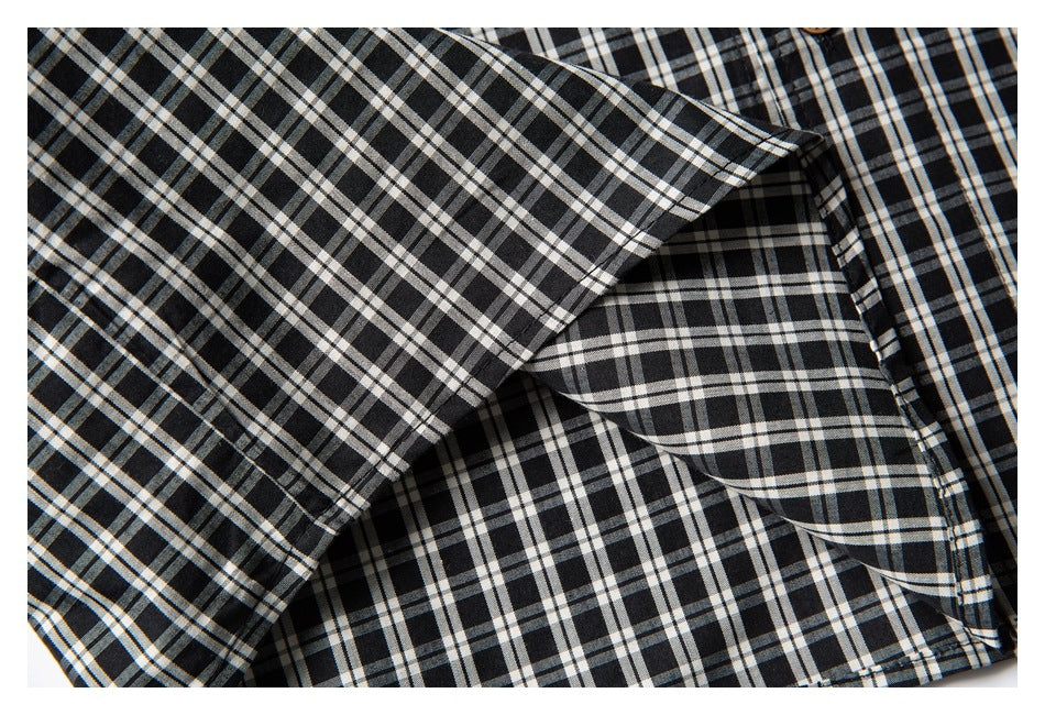 Close-up of the folded sleeve and stitched edge on a black-and-white checked shirt.