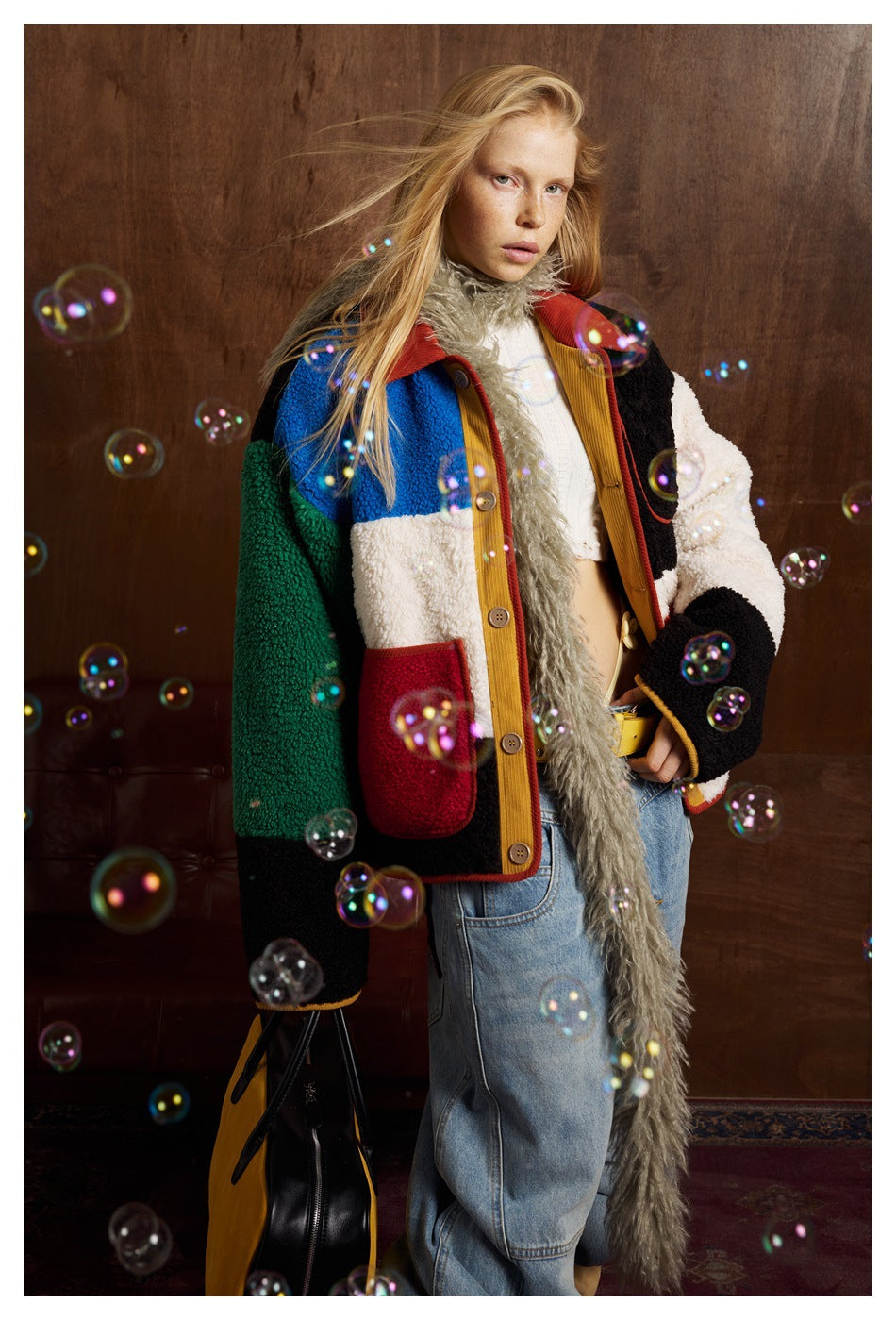 Model wearing an open color-block jacket with red pockets; decorative bubbles overlay the photo.