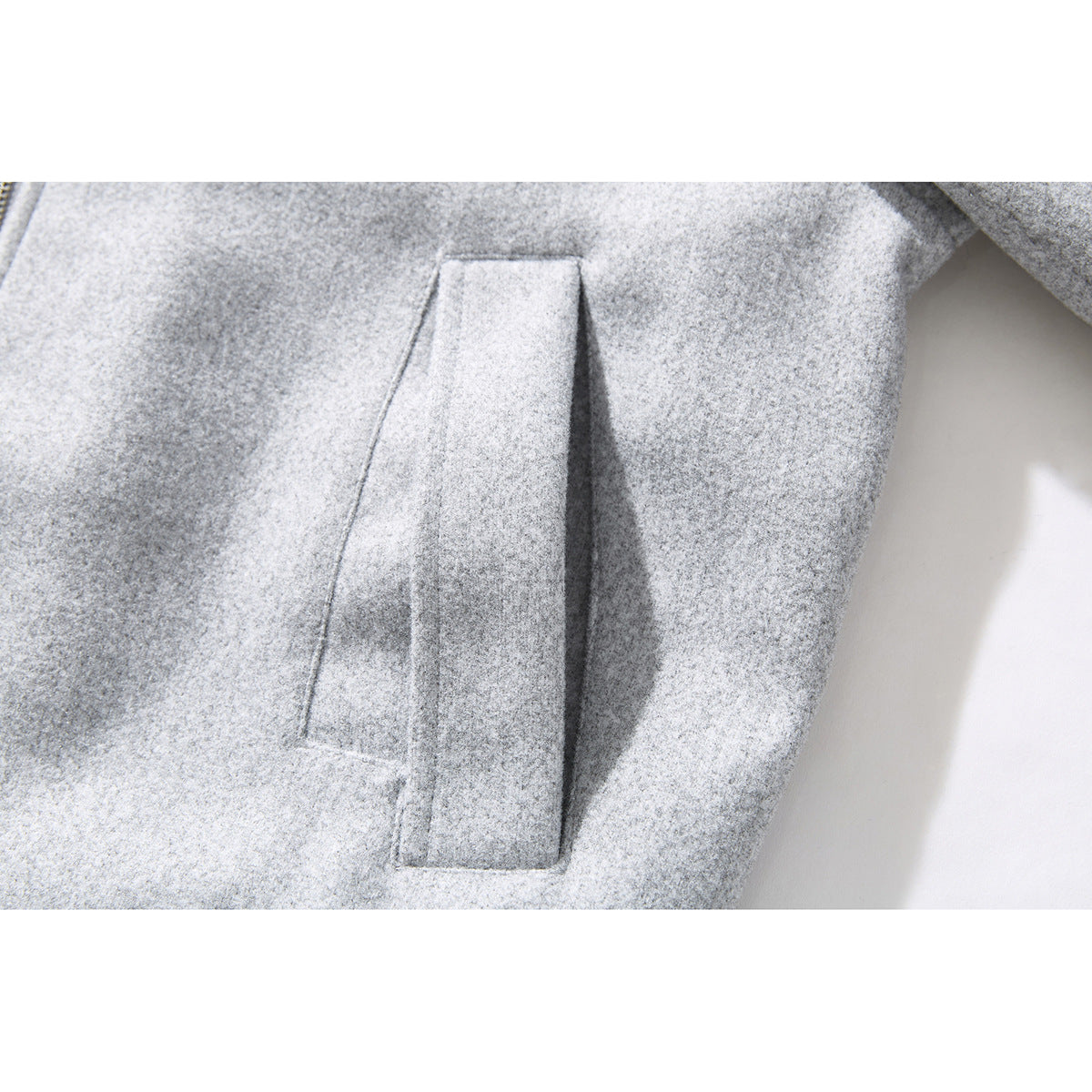 Close-up of a light gray jacket's slanted welt pocket.