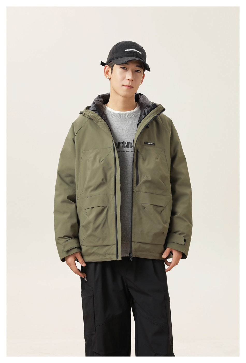 Front view of a model wearing an open olive hooded jacket over a gray shirt.