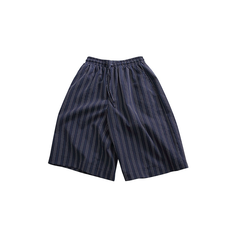 Front view of loose navy pinstriped shorts with an elastic drawstring waist, laid flat on a white background.