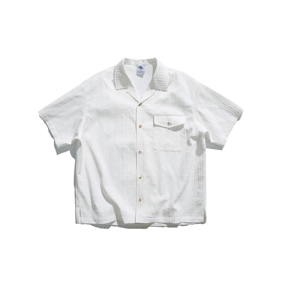 White short-sleeve camp-collar shirt with textured stripes, button front and chest flap pocket, flat lay