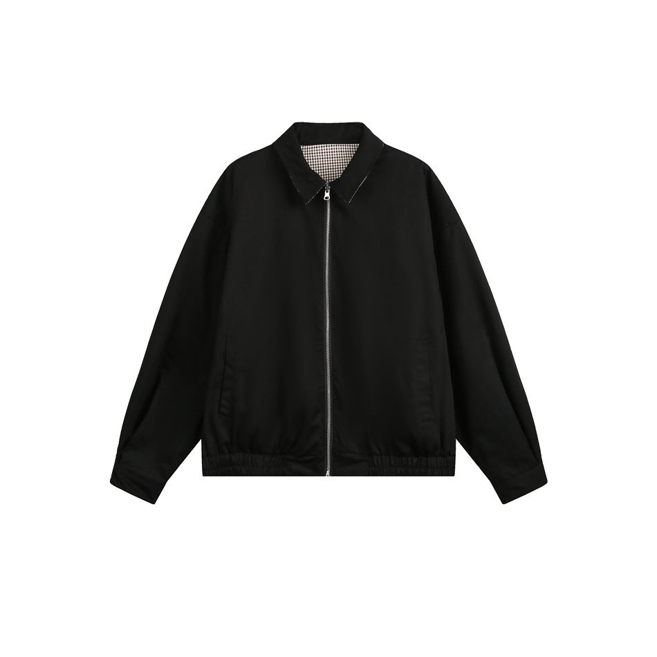 Front view of a black zip jacket with a pointed collar, check lining inside the neck, side pockets, and an elastic hem.