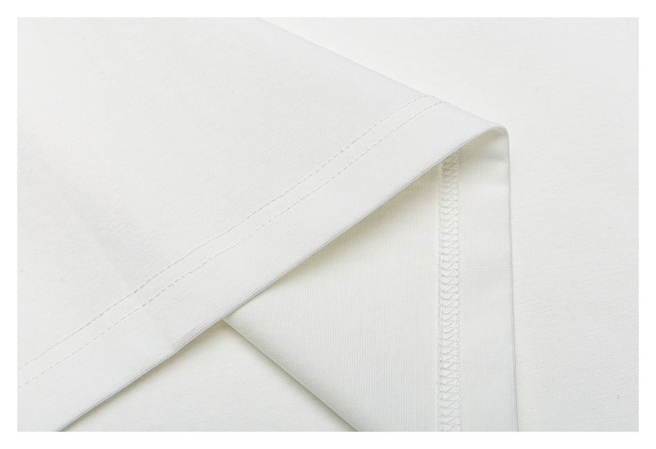 Close-up of a white T-shirt sleeve hem and interior overlock stitching.