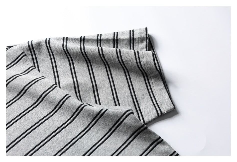 Close-up of the folded sleeve and cuff of a gray shirt with thin black stripes.