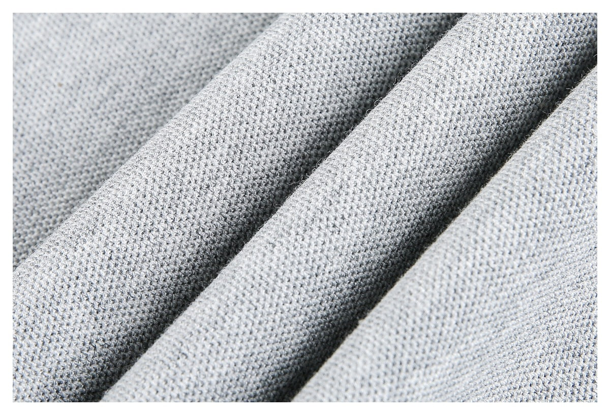 Close-up of pale gray knit fabric arranged in soft folds, showing the fine stitch texture.