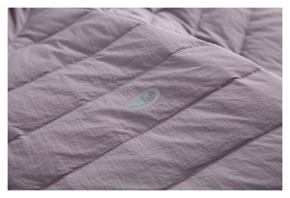 Quilted mauve-gray jacket fabric with a small tonal emblem.