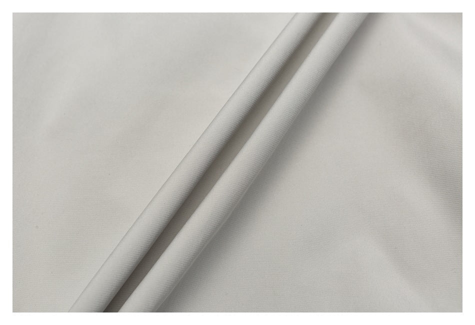 Close-up of light gray fabric folded into two diagonal ridges.