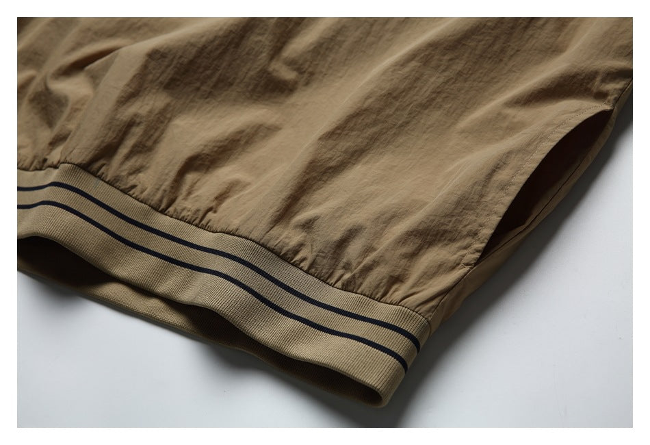 Close-up of the tan garment's ribbed hem band with two navy stripes.
