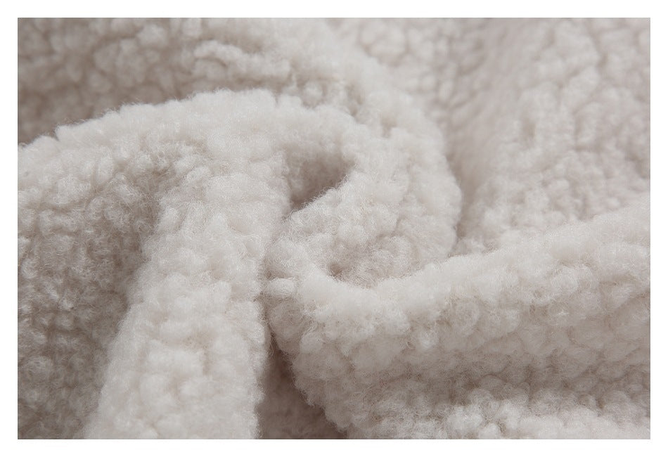 Macro view of the cream jacket's fluffy sherpa lining and a folded edge.