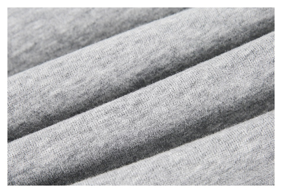 Close-up of light gray knit fabric folded into ridges.