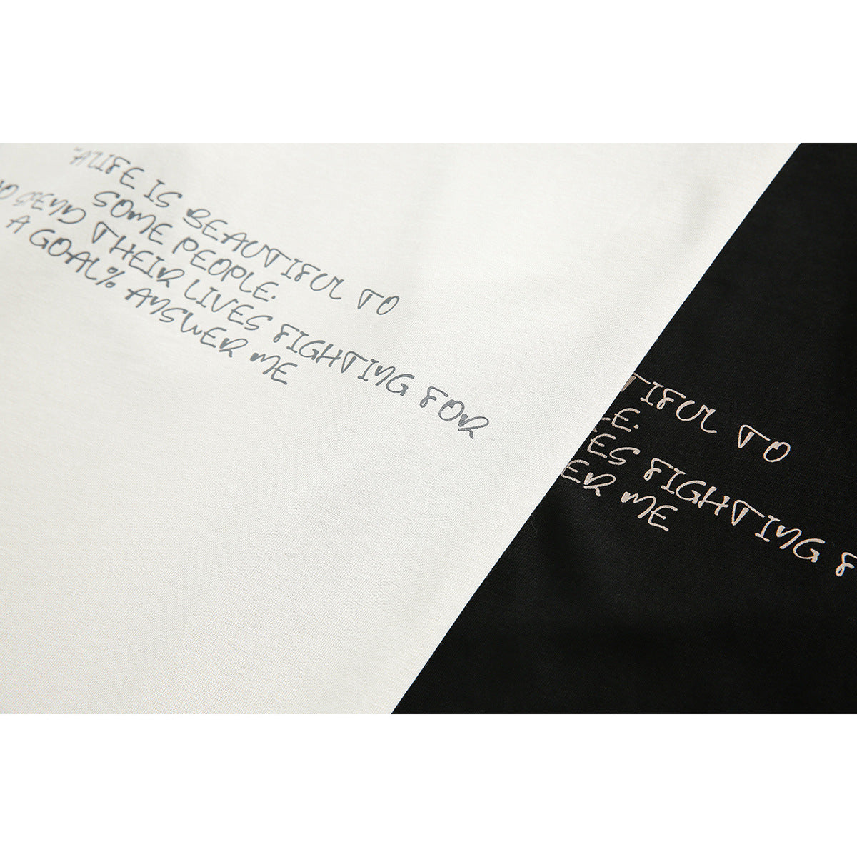 Close-up of a handwritten English quote printed across cream and black garment fabric.
