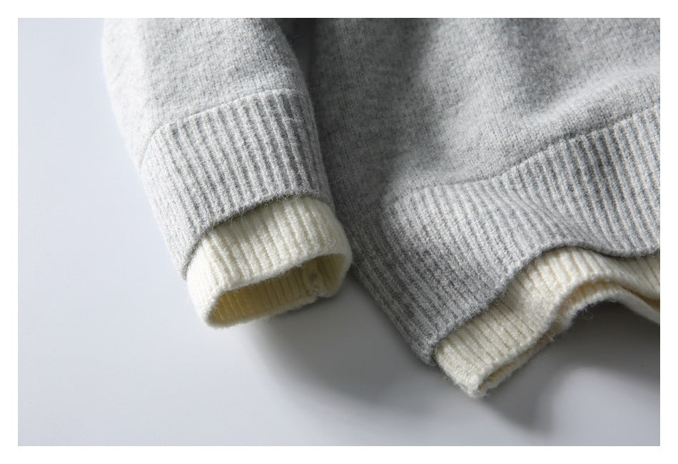 Close-up of the gray knit top's ribbed cuff and hem with a pale contrasting layer underneath.