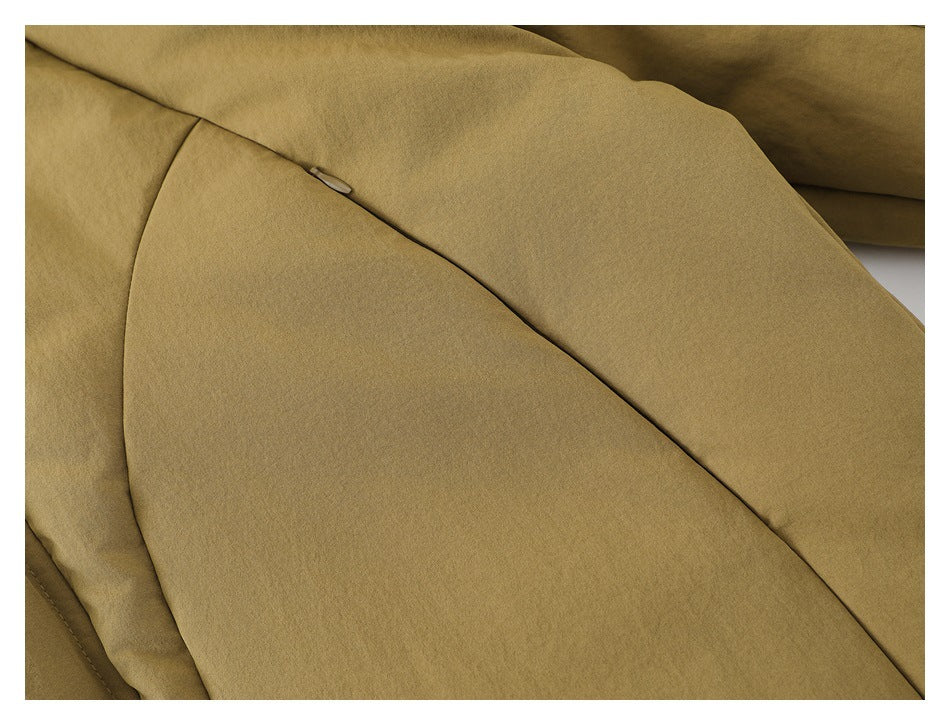Close-up of a diagonal seam and small concealed hardware on the tan jacket.
