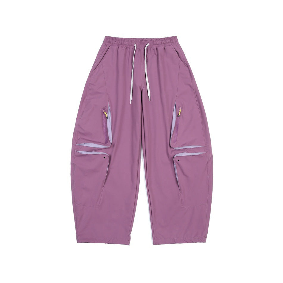 Purple wide-leg cargo pants with drawstring waist, zippered leg pockets and lower flap pockets, front flat view