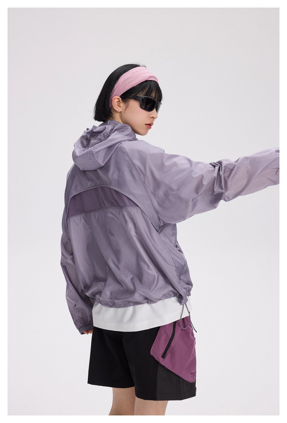 Close rear-side view of a lavender hooded jacket showing its mesh back vent and gathered hem.